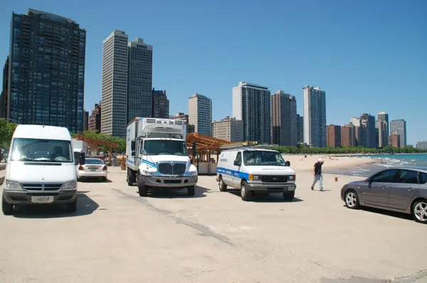 Temp-Master commercial HVAC service vehicles on-site at a Chicago lakefront project with city skyline in the background.